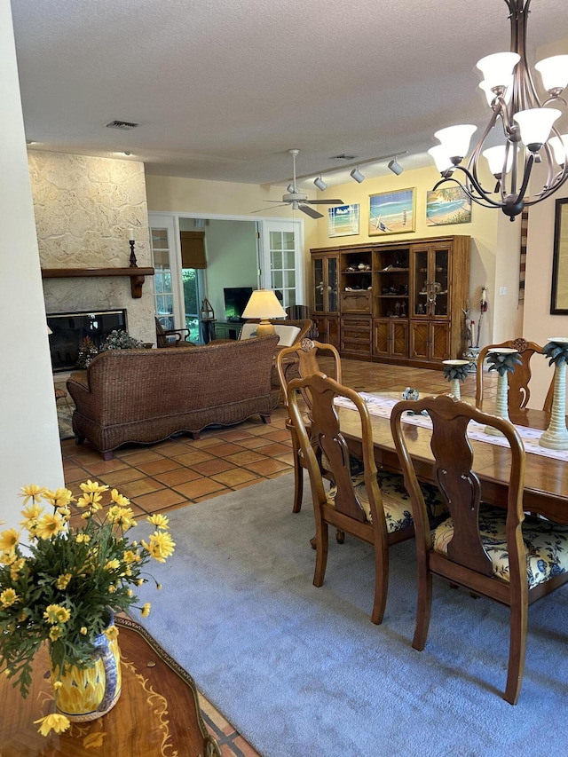 dining room featuring tile patterned flooring, ceiling fan with notable chandelier, and a fireplace