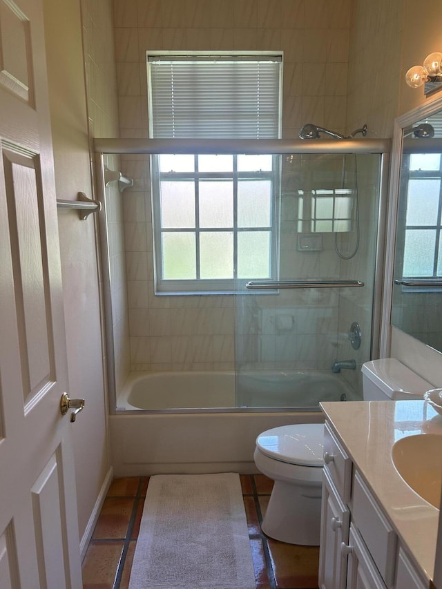 full bathroom featuring shower / bath combination with glass door, vanity, tile patterned floors, and toilet