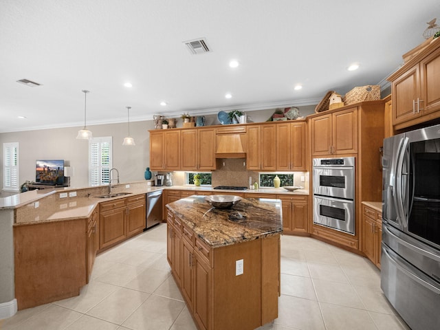 kitchen featuring kitchen peninsula, appliances with stainless steel finishes, premium range hood, crown molding, and pendant lighting