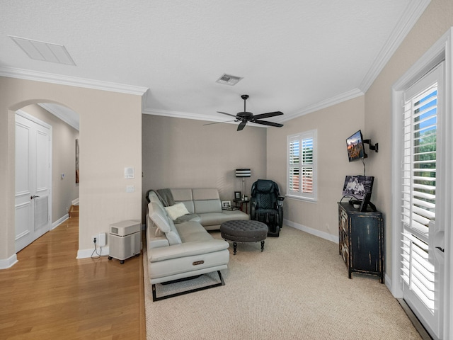 living room with light hardwood / wood-style flooring, ceiling fan, and crown molding