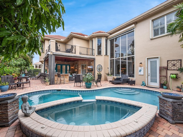 view of pool with an in ground hot tub, exterior bar, and a patio