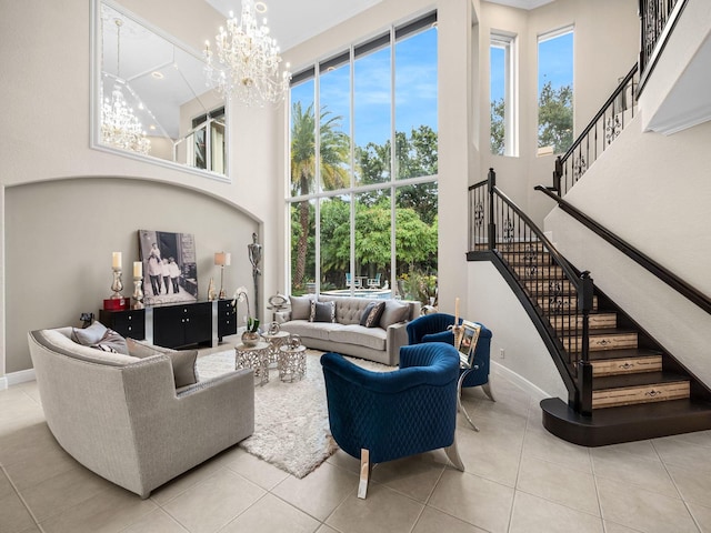 tiled living room featuring stairway, a high ceiling, a notable chandelier, and plenty of natural light