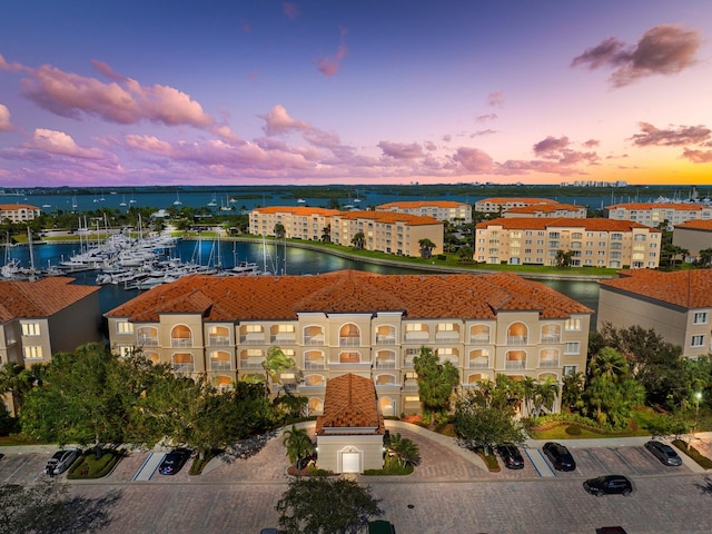 aerial view at dusk featuring a water view