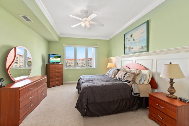 carpeted bedroom featuring ceiling fan and crown molding