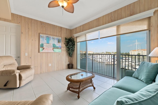 living room with a water view, light tile patterned floors, crown molding, and wooden walls