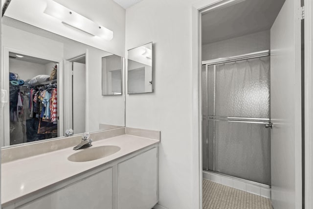 bathroom featuring tile patterned floors, vanity, and a shower with shower door