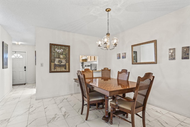 dining space featuring a chandelier and a textured ceiling