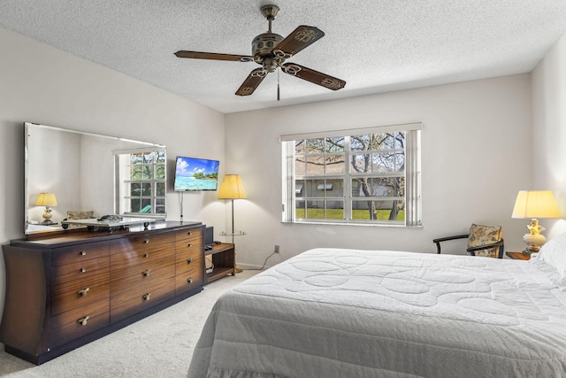 carpeted bedroom featuring ceiling fan, a textured ceiling, and multiple windows