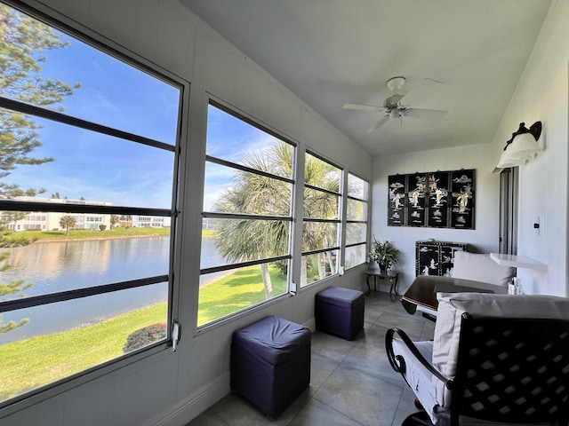 sunroom with a water view and ceiling fan