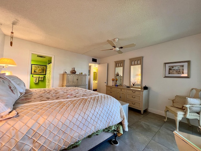 bedroom featuring tile patterned floors, ensuite bath, ceiling fan, and a textured ceiling