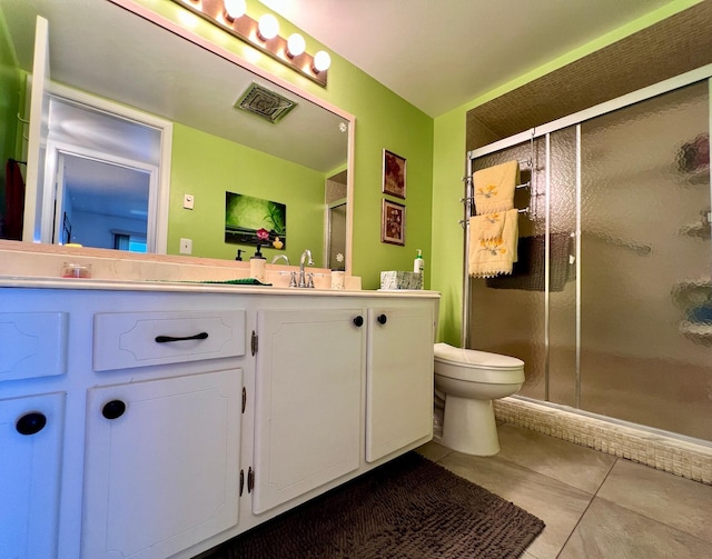 bathroom featuring tile patterned flooring, vanity, toilet, and a shower with door