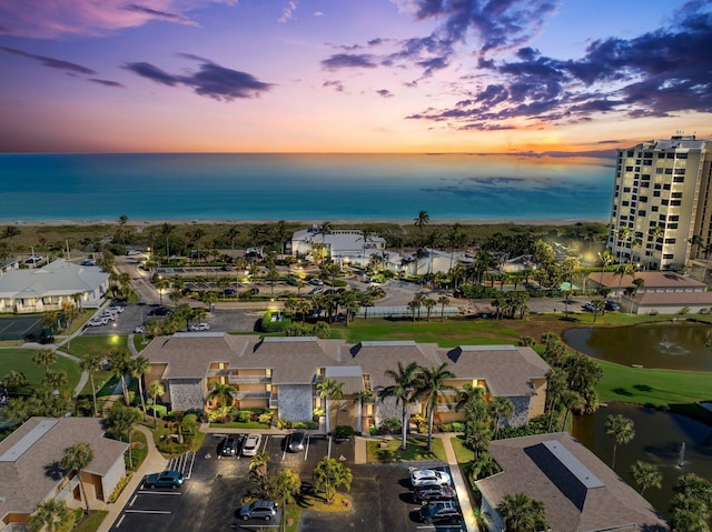 aerial view at dusk featuring a water view