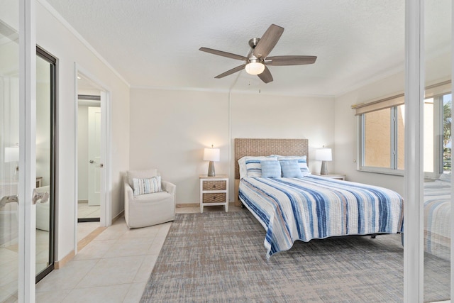 tiled bedroom with a textured ceiling, ceiling fan, and crown molding