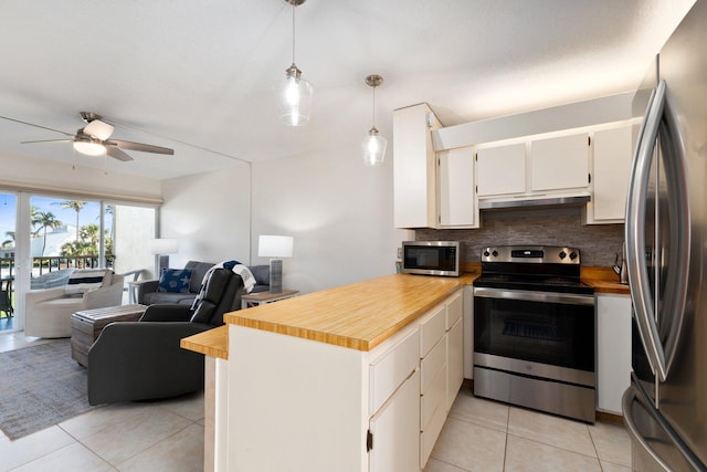 kitchen featuring backsplash, hanging light fixtures, light tile patterned floors, kitchen peninsula, and stainless steel appliances