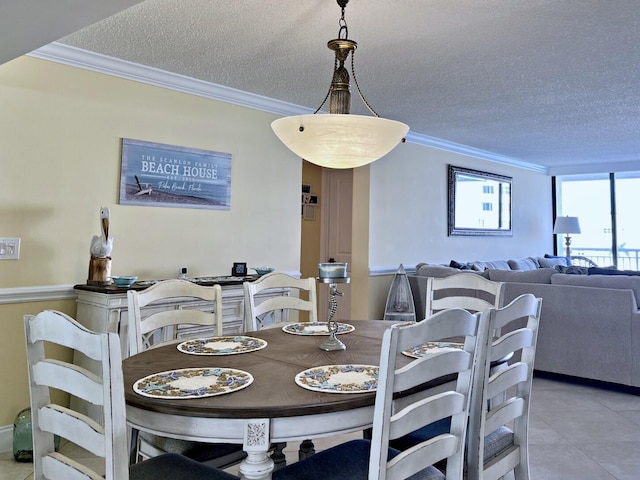 tiled dining room with a textured ceiling and crown molding