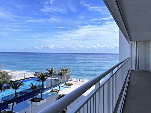 balcony with a water view and a view of the beach