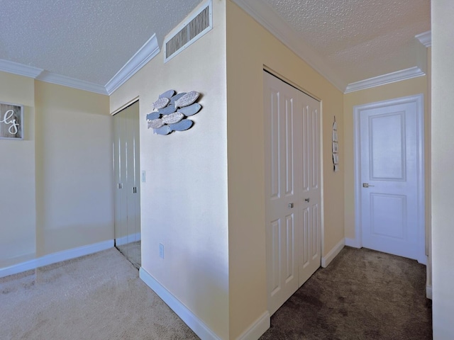 hall featuring carpet floors, a textured ceiling, and ornamental molding