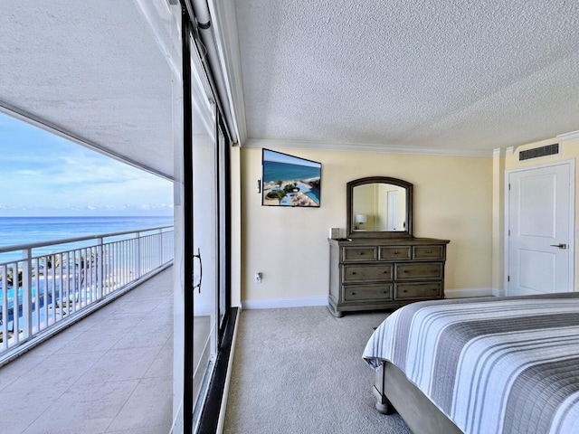 bedroom with a textured ceiling, a water view, a wall of windows, and crown molding