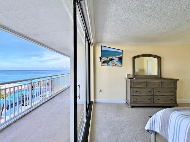 bedroom with expansive windows, crown molding, a water view, and a textured ceiling