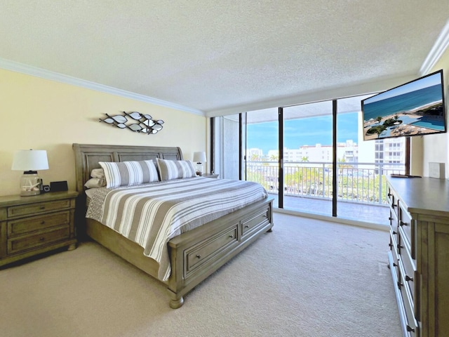 bedroom with a textured ceiling, a wall of windows, ornamental molding, and access to outside