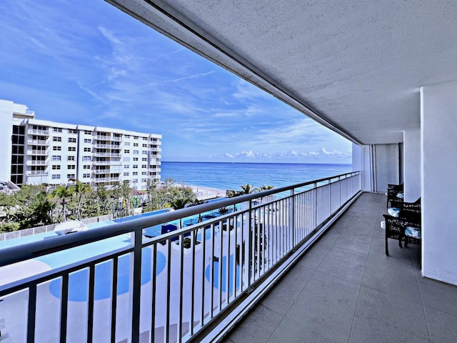 balcony featuring a water view and a view of the beach