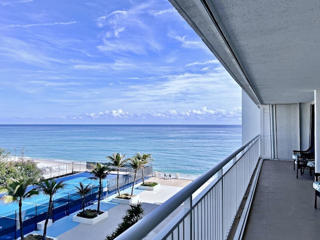 balcony featuring a water view and a beach view