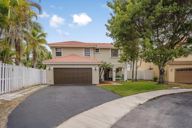 mediterranean / spanish-style home with a front yard and a garage