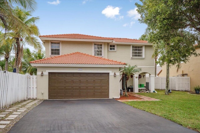 mediterranean / spanish-style house featuring a front yard and a garage