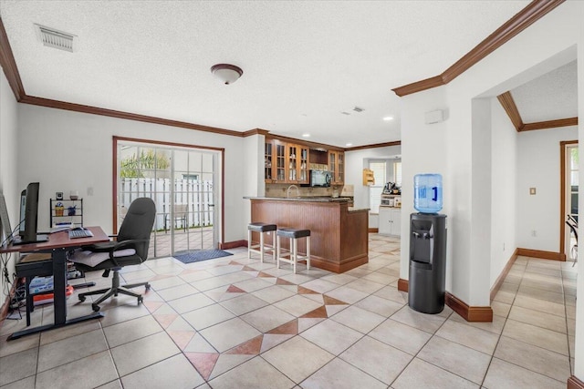 tiled office space with a textured ceiling, wet bar, and ornamental molding