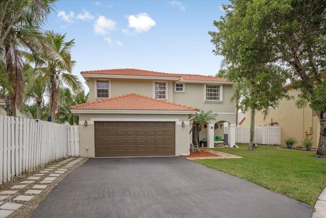 mediterranean / spanish home featuring a garage and a front yard