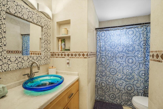 bathroom with walk in shower, vanity, tile walls, and toilet