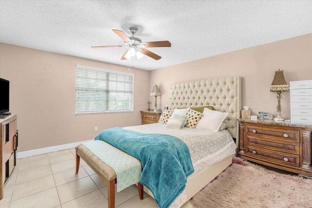 tiled bedroom with ceiling fan and a textured ceiling