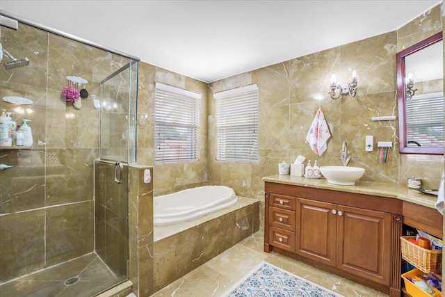 bathroom featuring plus walk in shower, vanity, and tile walls