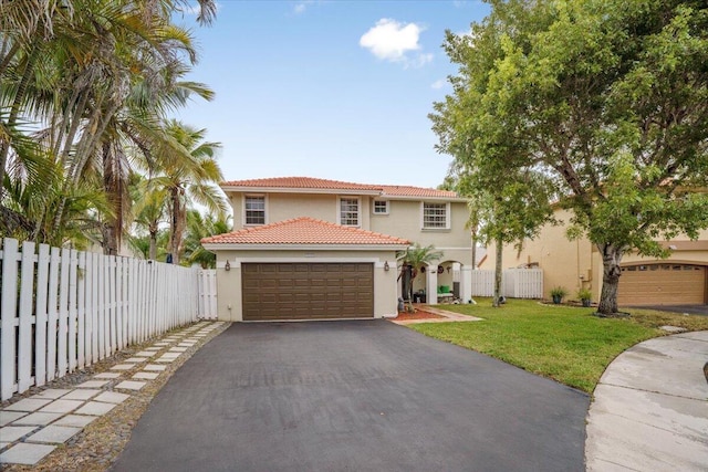 mediterranean / spanish home featuring a front lawn and a garage