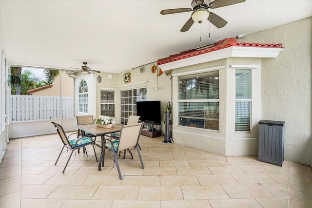 sunroom / solarium featuring plenty of natural light and ceiling fan