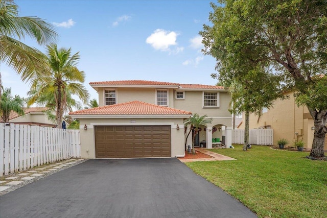 mediterranean / spanish-style house with a front yard and a garage