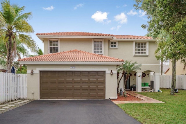 mediterranean / spanish-style home featuring a garage and a front lawn