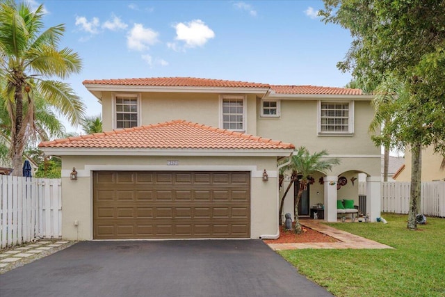 mediterranean / spanish house featuring a front yard and a garage