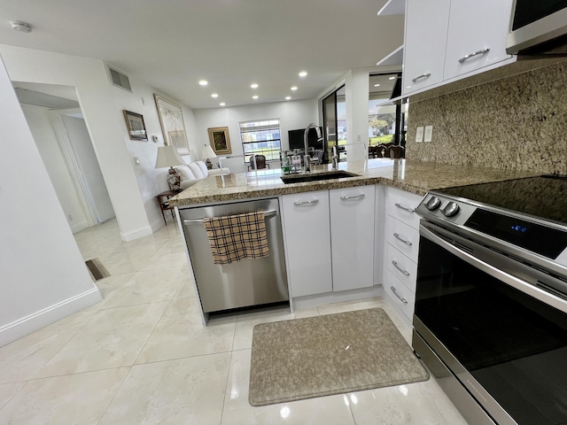 kitchen featuring kitchen peninsula, sink, white cabinets, and stainless steel appliances