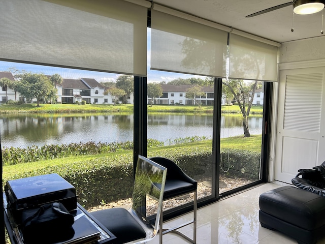 sunroom / solarium with a water view and ceiling fan