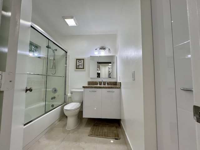 full bathroom featuring shower / bath combination with glass door, tile patterned flooring, vanity, and toilet