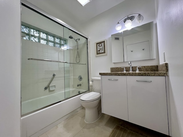 full bathroom featuring tile patterned floors, toilet, vanity, and combined bath / shower with glass door