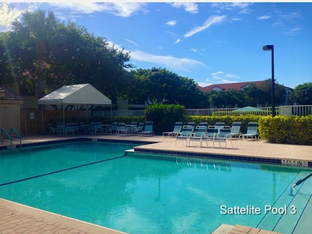 view of swimming pool with a mountain view and a patio