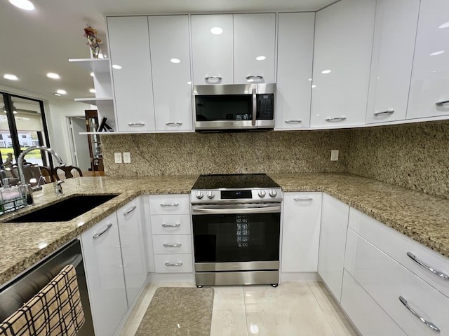 kitchen with white cabinets, appliances with stainless steel finishes, decorative backsplash, and sink