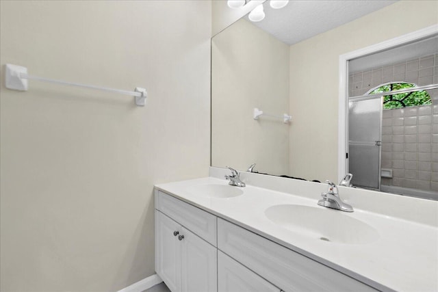 bathroom featuring vanity, an enclosed shower, and a textured ceiling