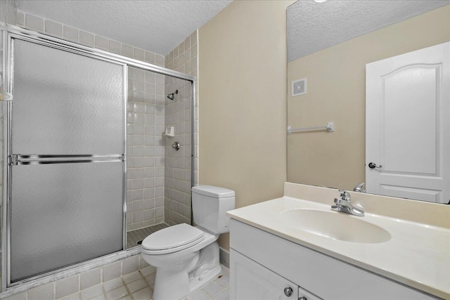 bathroom with a textured ceiling, vanity, toilet, and a shower with shower door