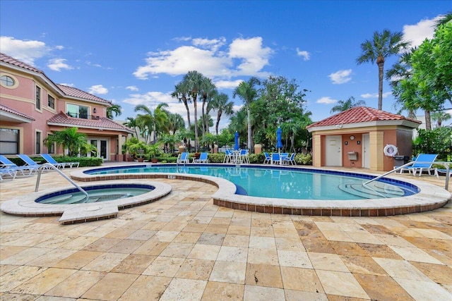 view of swimming pool with a patio and a hot tub