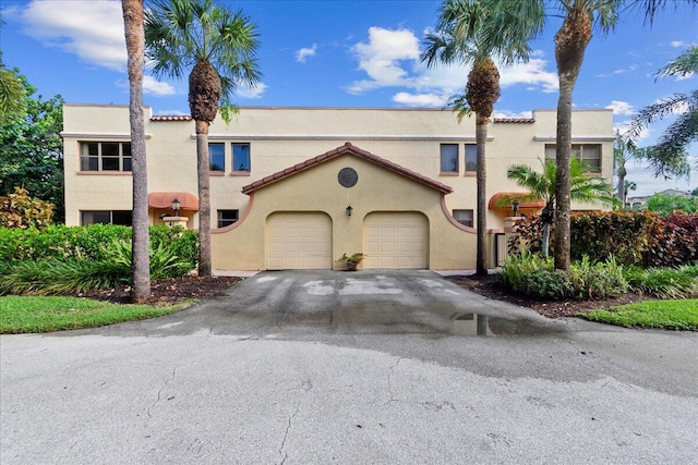41 Uno Lago Dr, Juno Beach, FL 33408 - view of front of home featuring stucco siding, asphalt driveway, and an attached garage