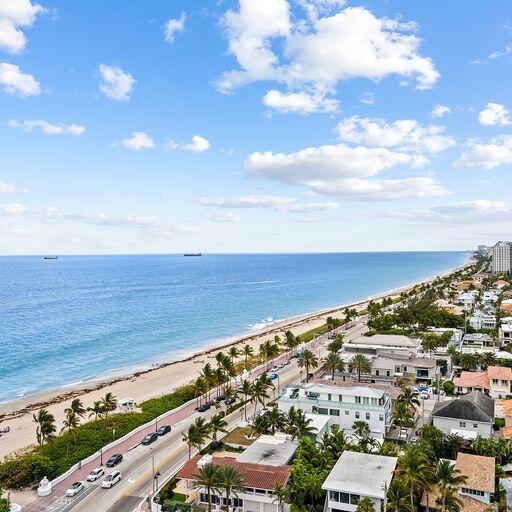 birds eye view of property with a water view and a beach view