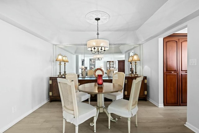 dining area featuring light wood-type flooring and a notable chandelier